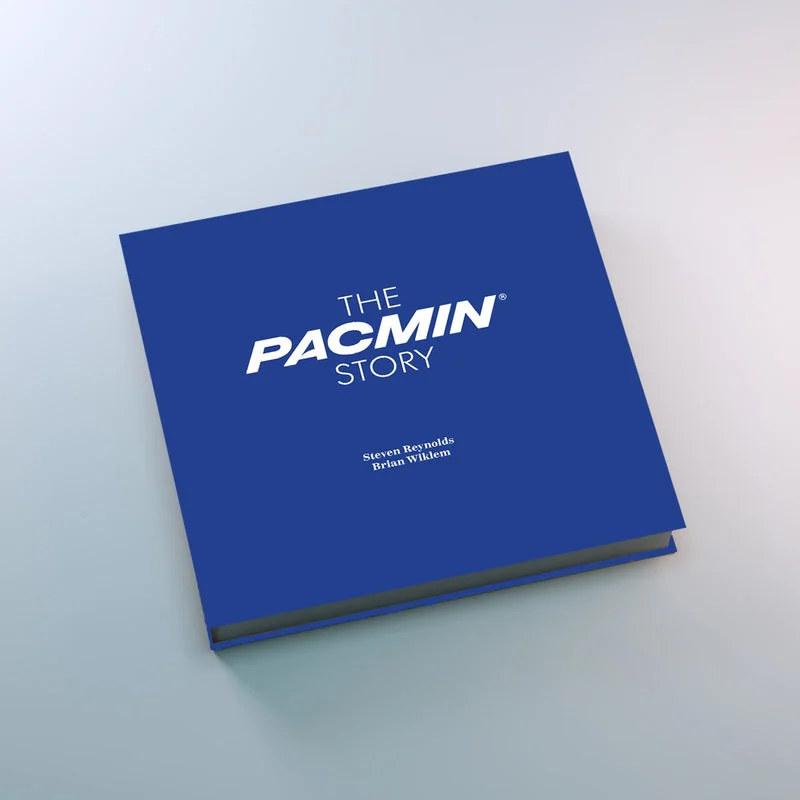 The Pacmin Story hardcover with the limited "Pacmin Blue" dust jacket, a deep blue cover with the white Pacmin wordmark